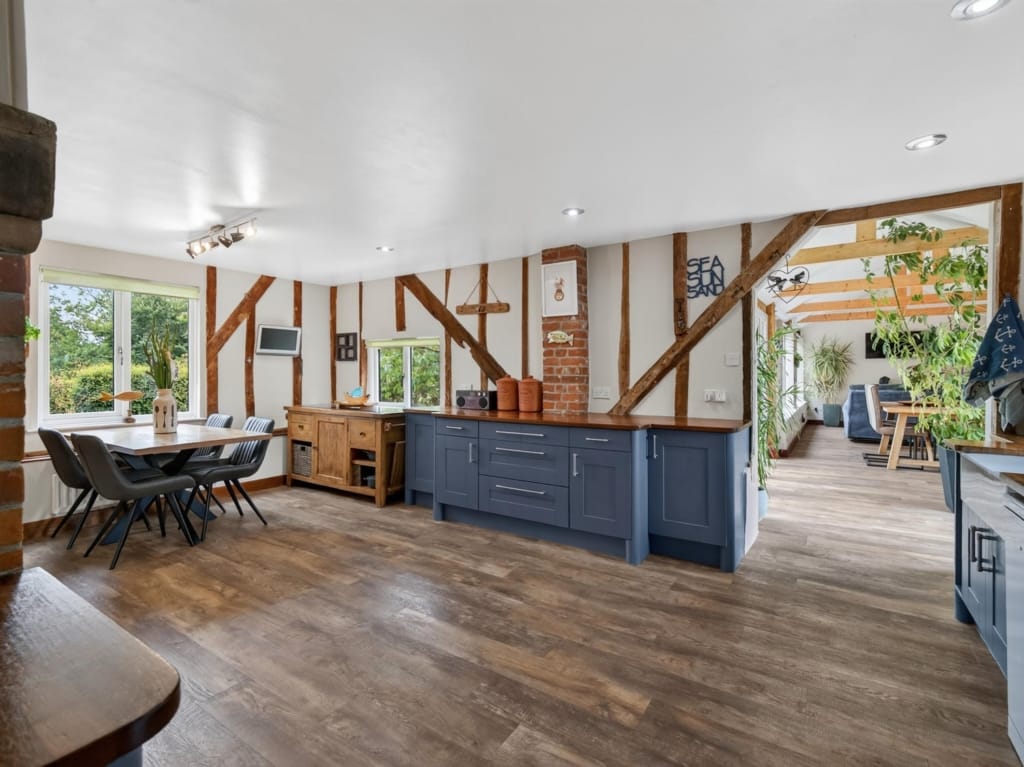 Kitchen and breakfast room with navy cabinetry, oak worktops, exposed timber frame, and dining area, The Tithe Barn, Sisland, Norfolk