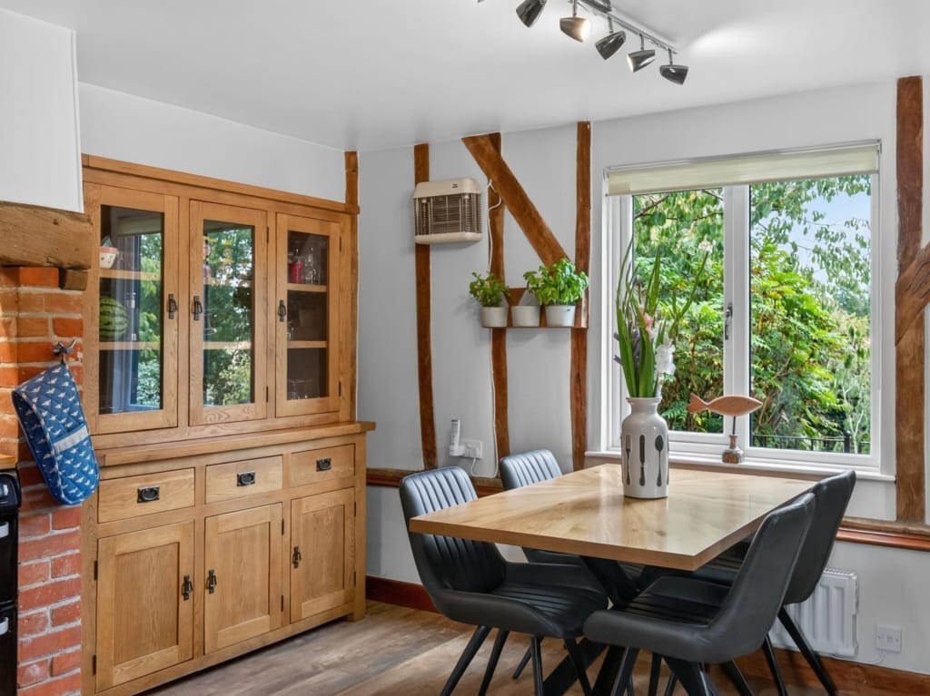 Kitchen and breakfast room with oak dresser, dining table, exposed timber frame posts, and garden views, The Tithe Barn, Sisland, Norfolk