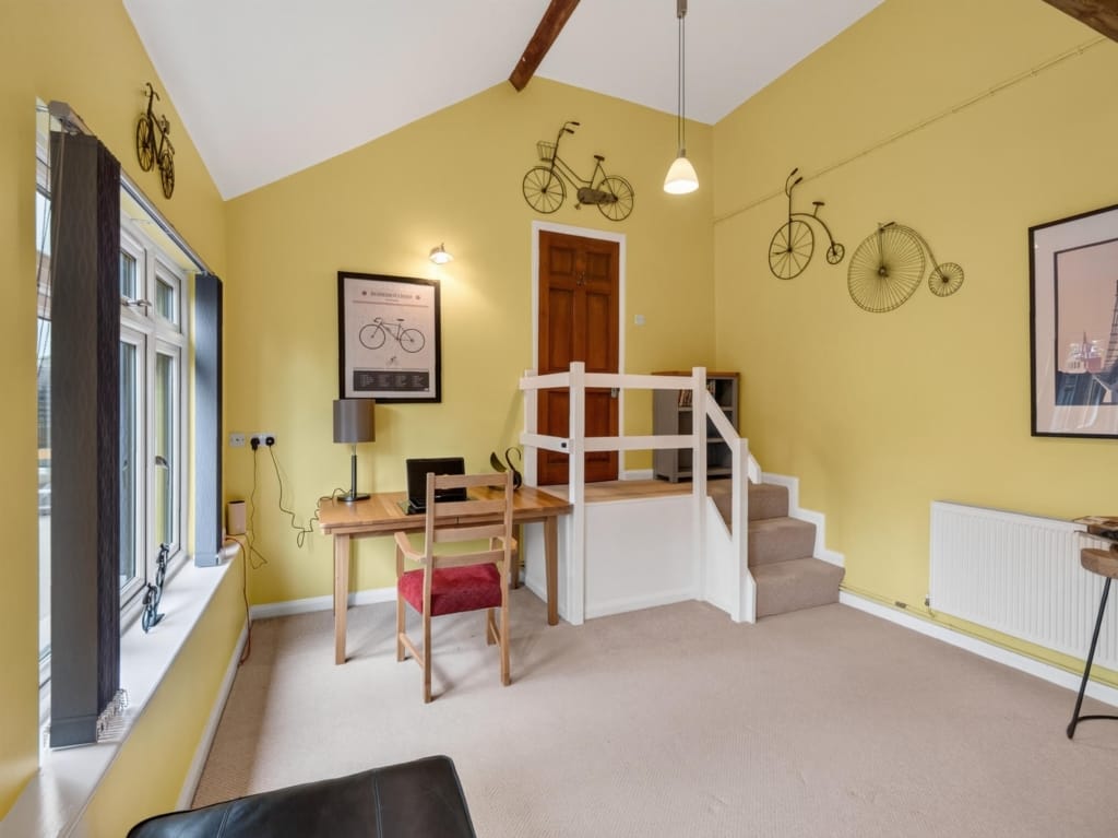Holiday barn sitting room with vaulted ceiling, timber desk, and staircase to upper level, The Tithe Barn, Sisland, Norfolk