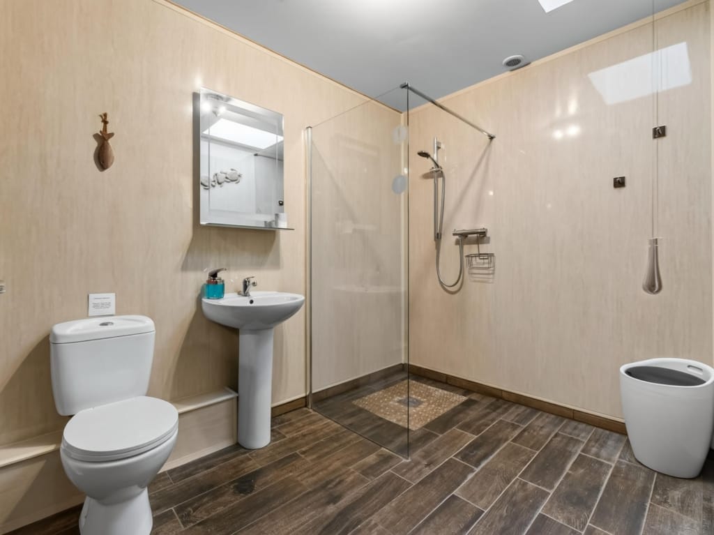 Bathroom with walk-in glass shower, pedestal basin, and wood-effect floor tiles, Owl Barn, Sisland, Norfolk