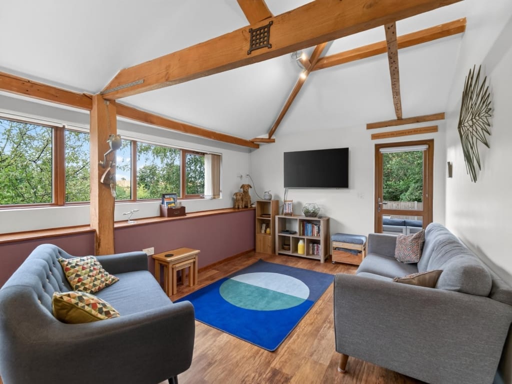 Owl Barn sitting room with vaulted oak beams, grey sofas, and tree-canopy views, The Tithe Barn, Sisland, Norfolk