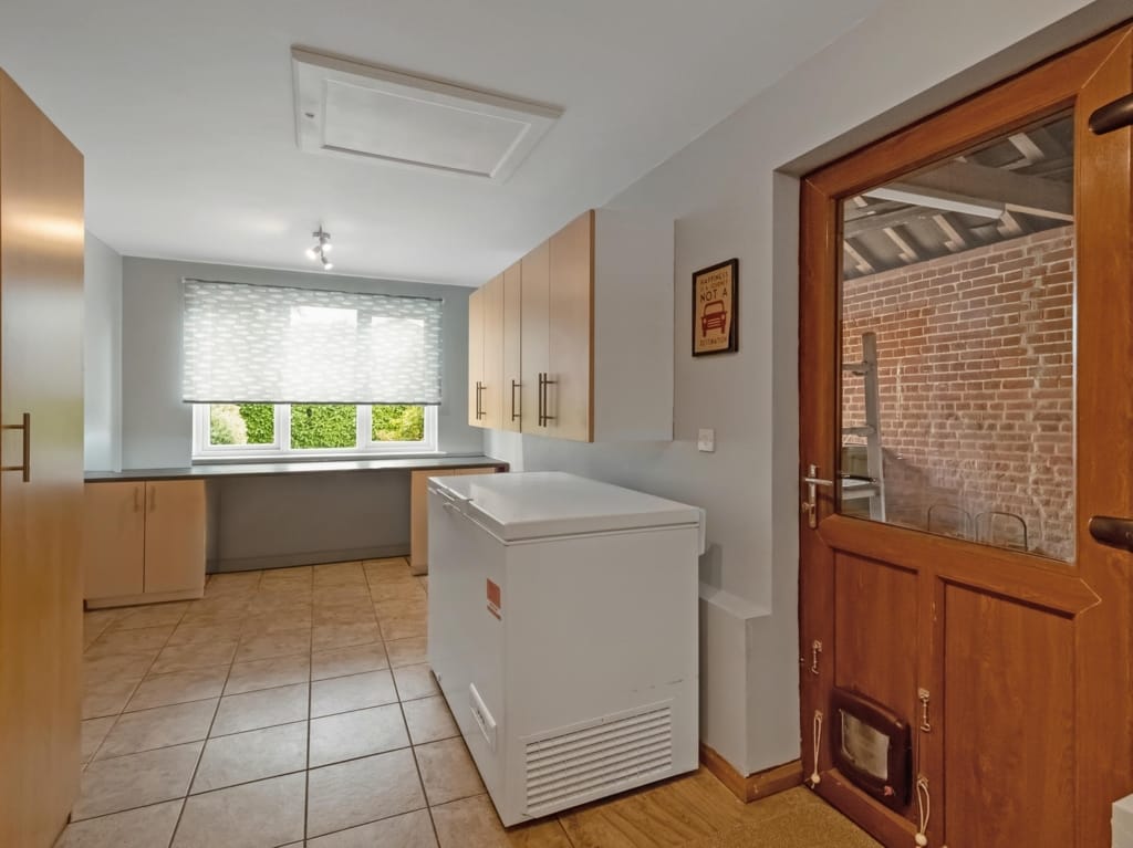 Utility room with chest freezer, fitted wall cabinets, and stable door to exposed brick outbuilding, The Tithe Barn, Sisland, Norfolk