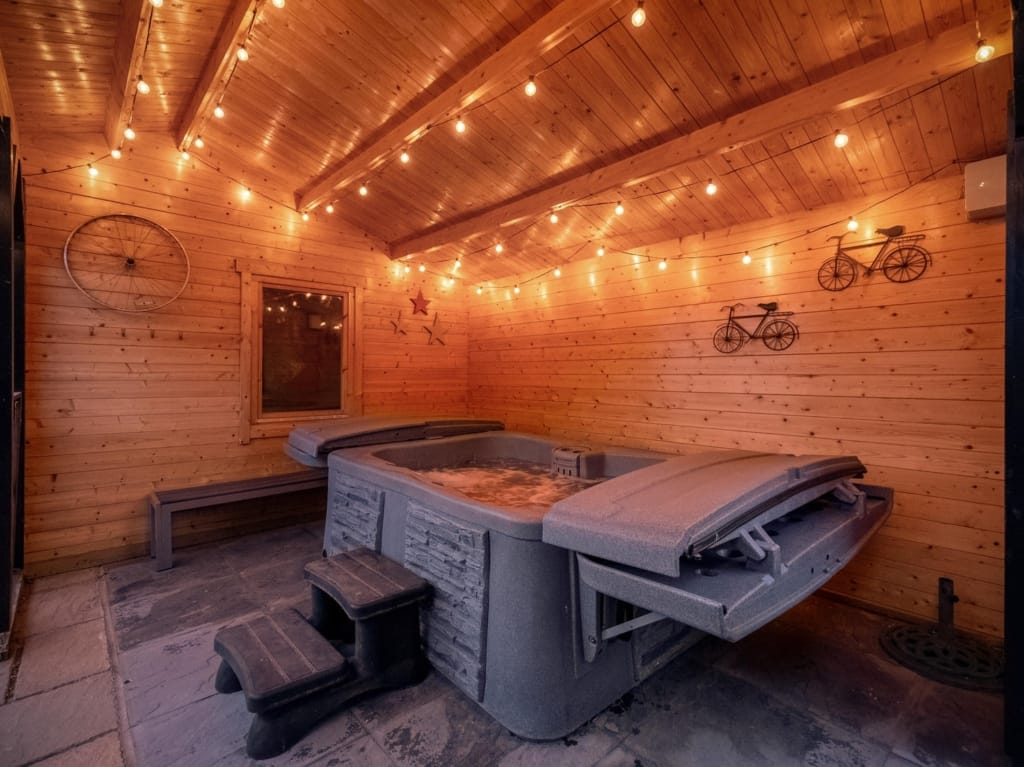 Timber-clad hot tub enclosure with festoon lighting, stone-effect spa and slate floor, The Tithe Barn, Sisland, Norfolk