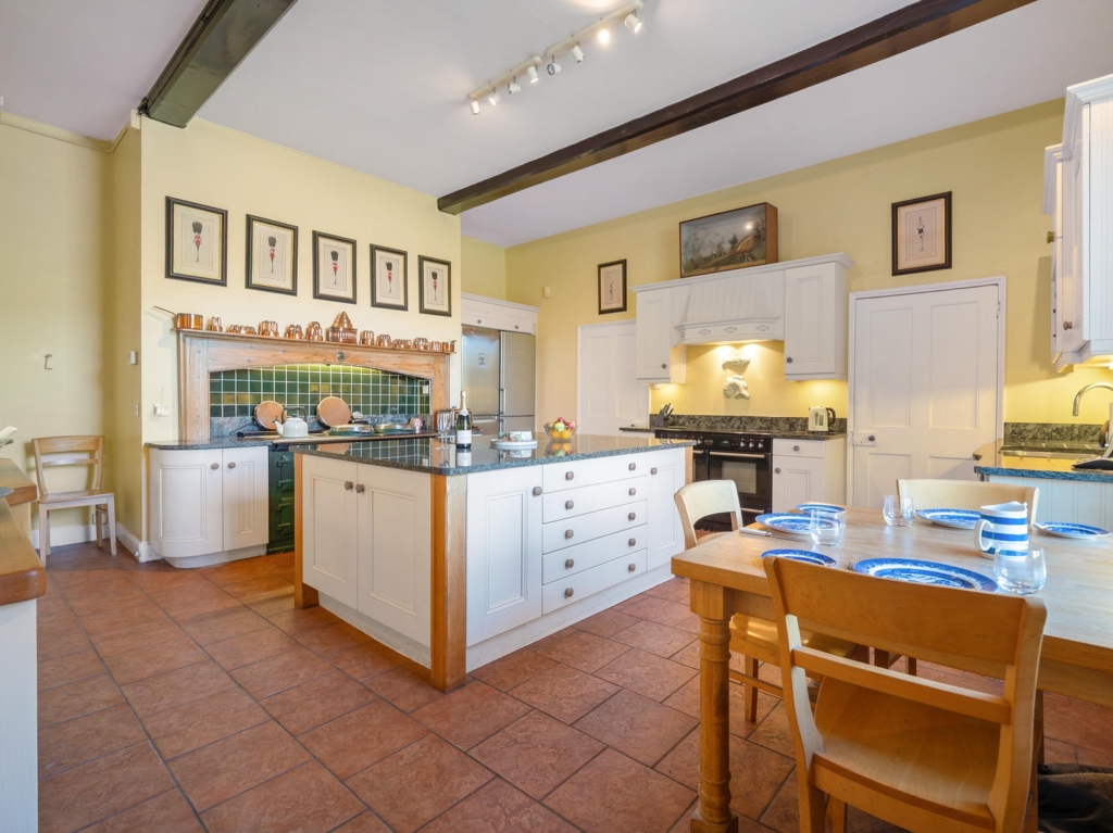 Spacious farmhouse kitchen and dining area with exposed beams at Loddon Hall, Norfolk