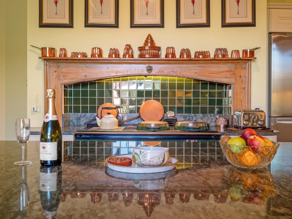 Aga, granite island and copper collection in the country kitchen at Loddon Hall, Norfolk