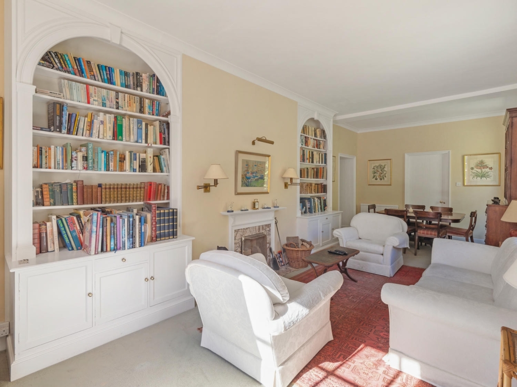Reception room with arched bookcases and fireplace at Loddon Hall, Norfolk