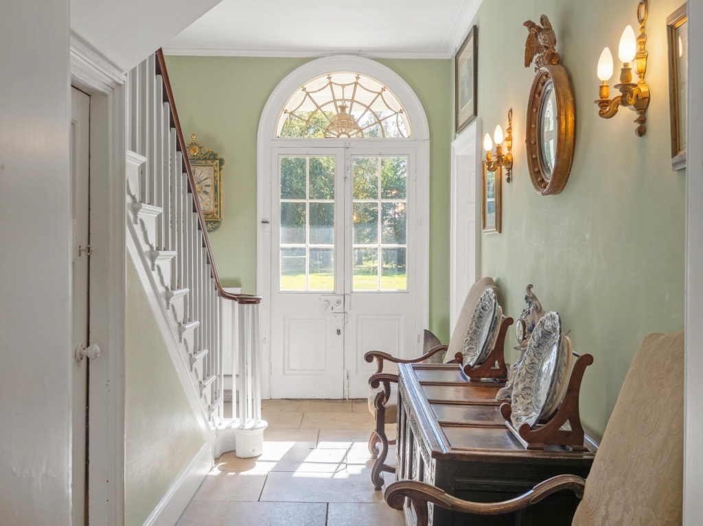Stone-flagged entrance hall with staircase and fanlit double doors at Loddon Hall, Norfolk