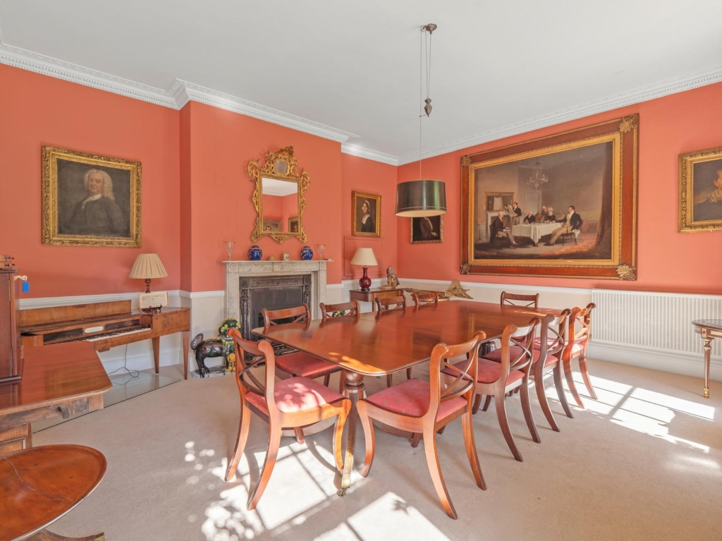 Formal dining room with cornicing, marble fireplace and mahogany table at Loddon Hall