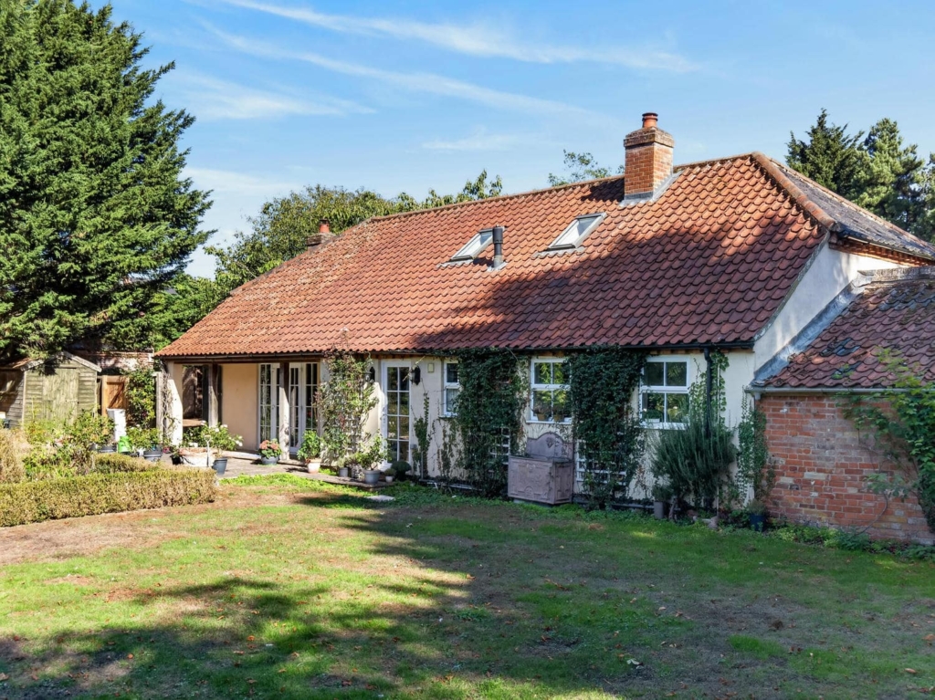 Rear of Loddon Hall Cottage, a red-tiled house with French doors and garden, Norfolk