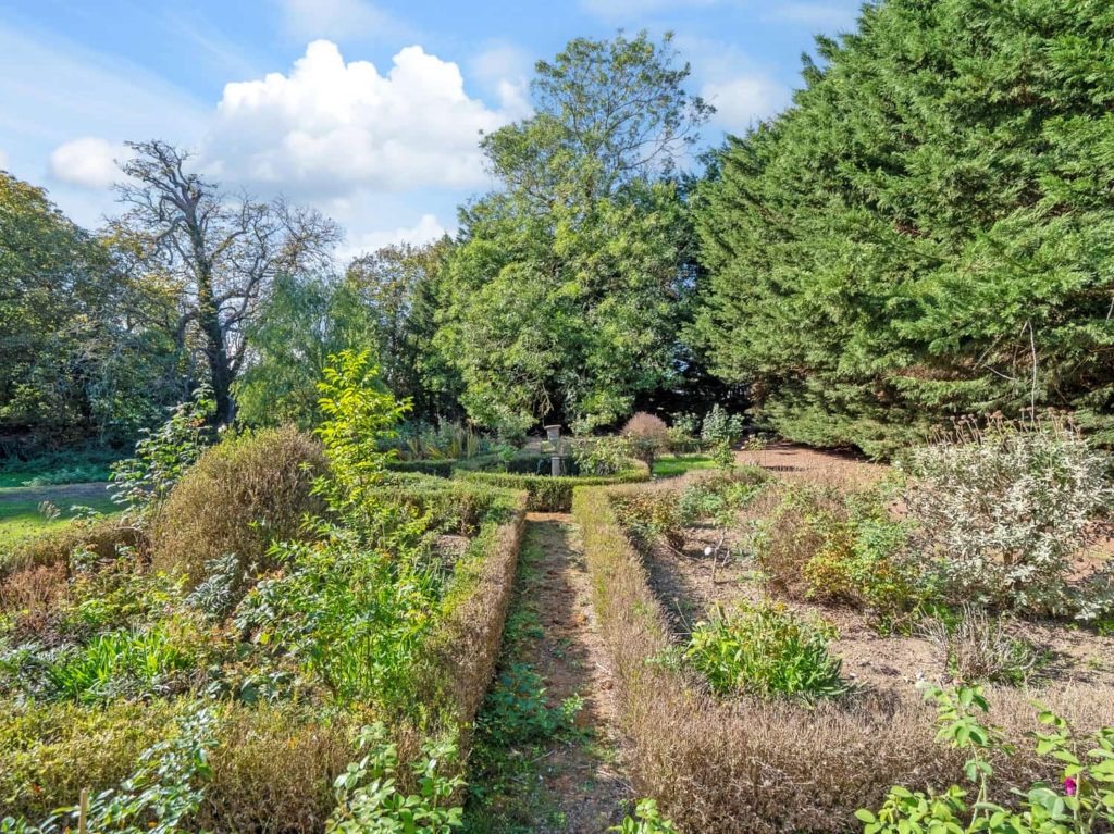 Formal parterre and clipped hedging in the garden of Loddon Hall Cottage, Norfolk