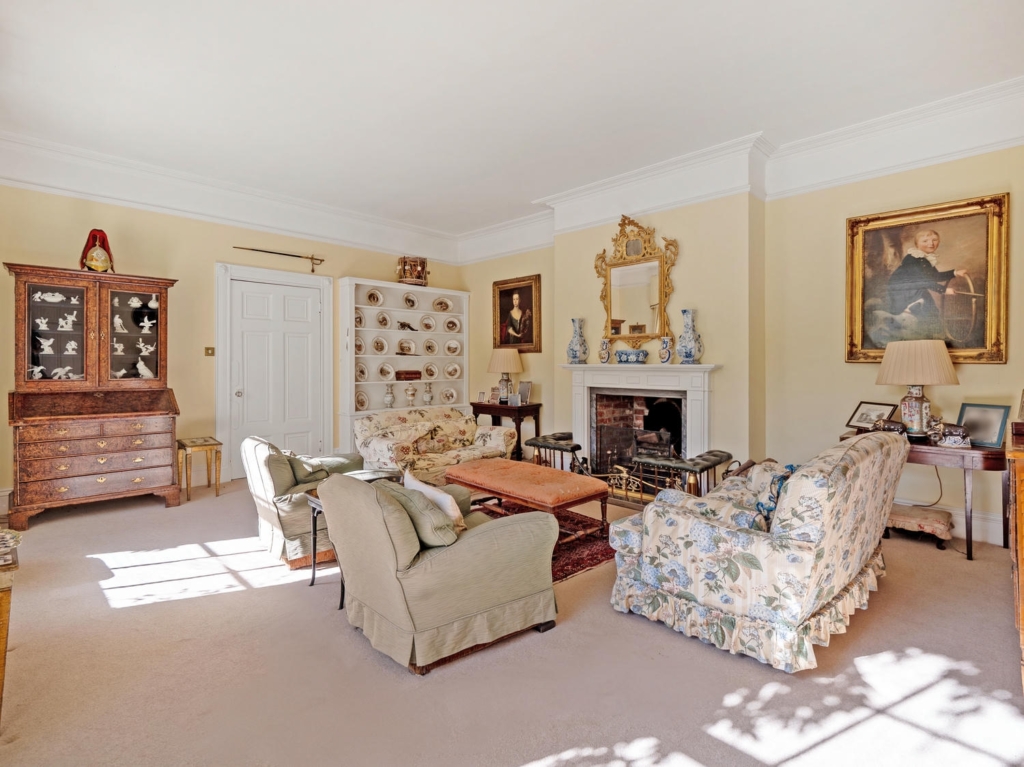 Elegant drawing room with antique furniture and fireplace at Loddon Hall, Norfolk