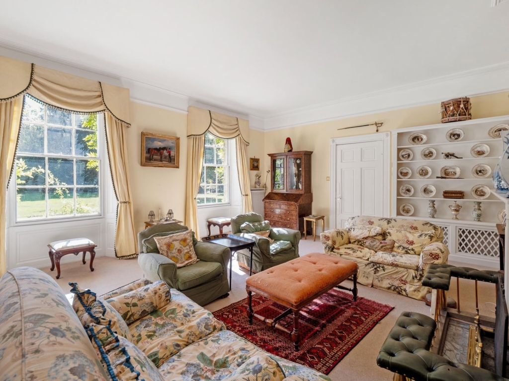 Drawing room with sash windows, period fireplace and sitting area at Loddon Hall, Norfolk