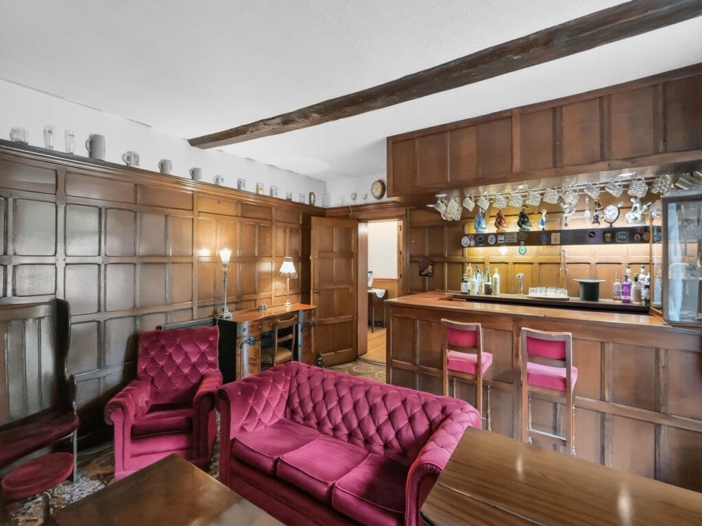 Bury's Hall panelled bar room with velvet sofas and timber ceiling beam