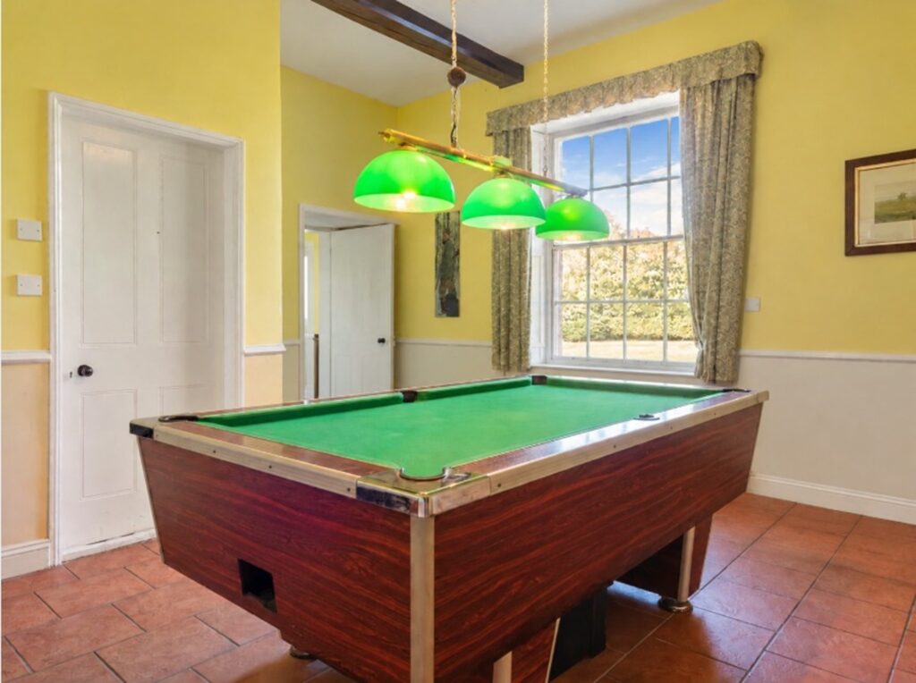 Games room with pool table and tall sash window at Loddon Hall, Norfolk